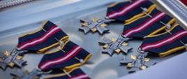 Na zdjęciu widoczna srebrna taca a na niej odznaczenia krzyże srebrno-złote na wstążce koloru granatowego.