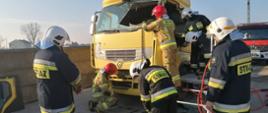 Warsztaty z zakresu ratownictwa technicznego. Złomowisko w Chojnie. Strażacy przygotowują sprzęt niezbędny do odciągnięcia kolumny kierowniczej samochodu ciężarowego. Trzech z nim znajduje się na podeście ratowniczym. 