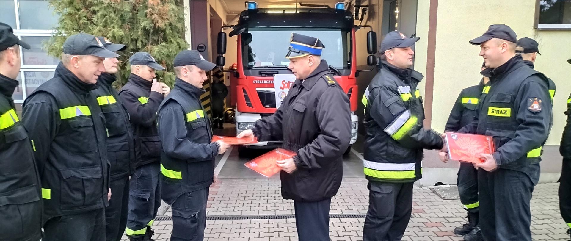 Na zdjęciu widać funkcjonariuszy odbierających decyzje 