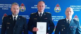 strażak otrzymujący nagrodę z Komendantem i Dowódcą JRG 