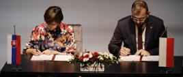 Minister Grzegorz Puda siedzi przy stole i podpisuje umowę o dofinansowanie kultury w programie Interreg Polska-Słowacja 2021-2027