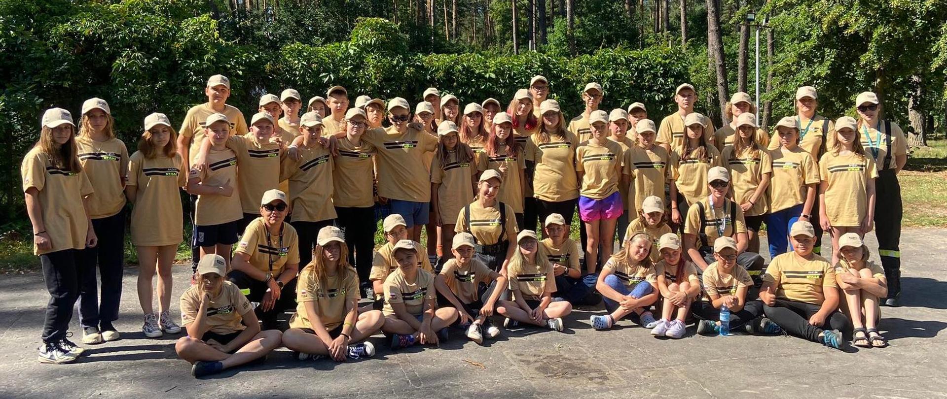 Młodzież i opiekunowie na zdjęciu grupowym