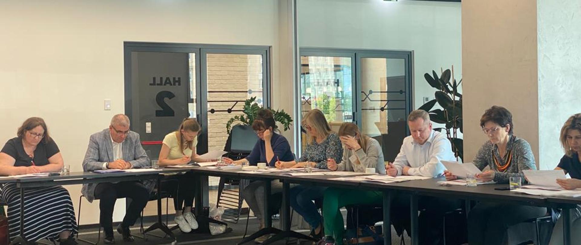 Uczestnicy warsztatów dla organów administracji architektoniczno-budowlanej , siedzą za stołami wpatrując się w materiały