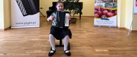 Uczennica z akordeonem podczas występu konkursowego.