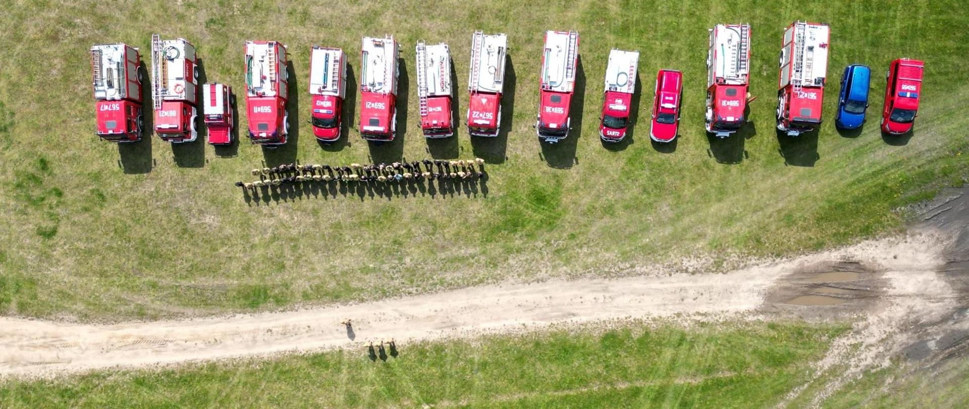 Wozy i strażacy stoją na placu ćwiczeń 