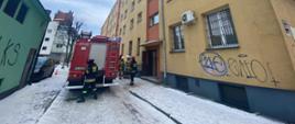 Przybyłe na miejsce zdarzenia zastępy straży pożarnej prowadzą działania w budynku mieszkalnym wielorodzinnym w Lęborku