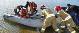 Akcja "Łabędź" Strażacy przy pomocy "cywilów" wodują ponton. Na jego pokładzie znajduje się trzech innych strażaków. 