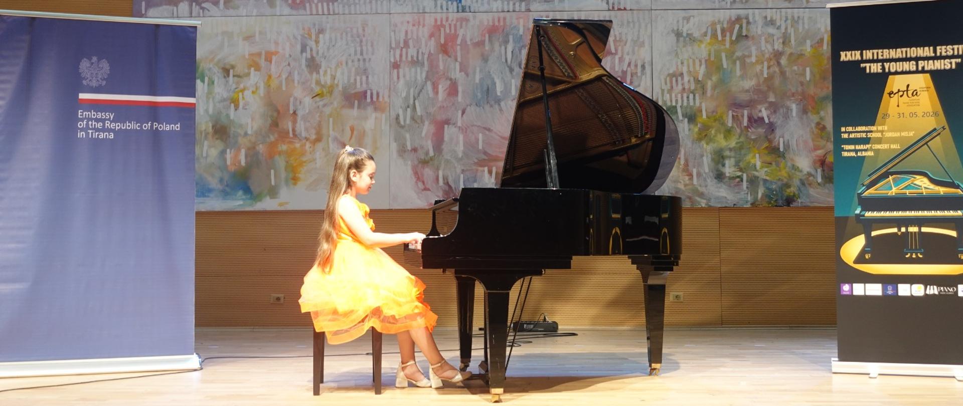 A girl playing the piano during the final of the 29th International Festival "The Young Pianist".