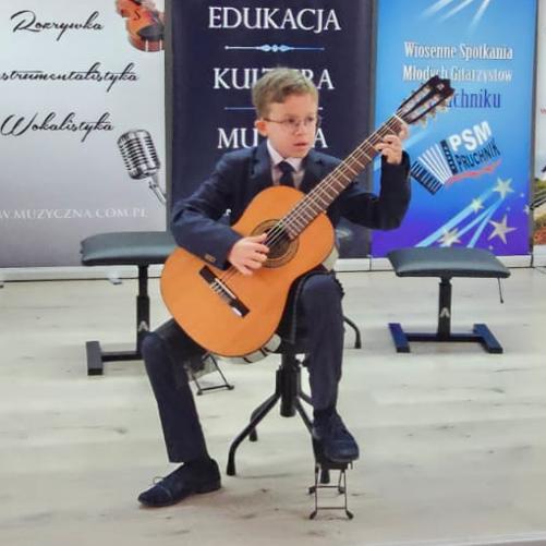 Zdjęcie grającego na gitarze Tomka Klebeko na konkursie w Pruchniku