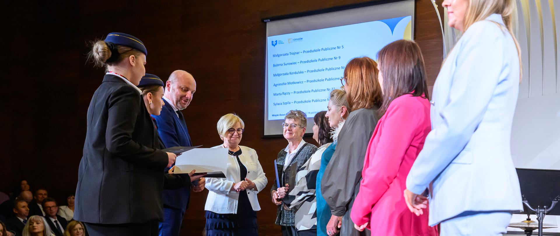 Zdjęcie przedstawia wojewodę podkarpackiego Teresę Kubas-Hul, prezydenta Rzeszowa Konrada Fijołka oraz nauczycieli podczas Dnia Edukacji Narodowej