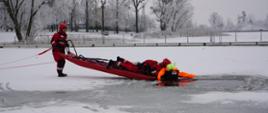 Strażacy podejmujący fantoma z przerębla przy pomocy deski lodowej według obowiązujących w PSP zasad.