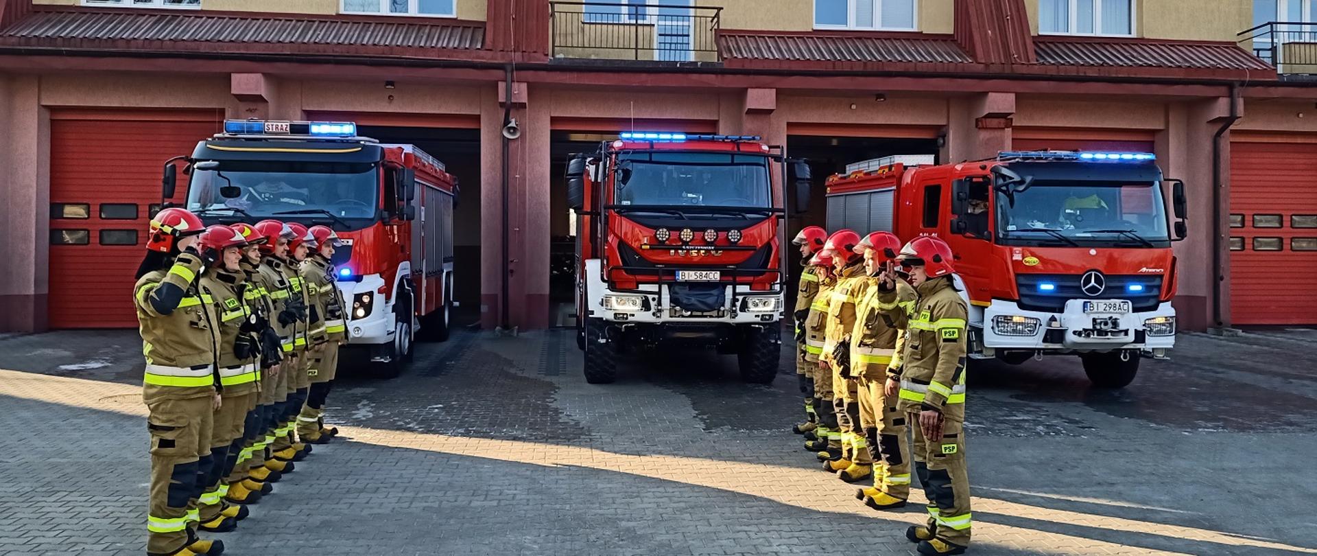 Zdjęcie strażaków w tle samochody pożarnicze i budynek