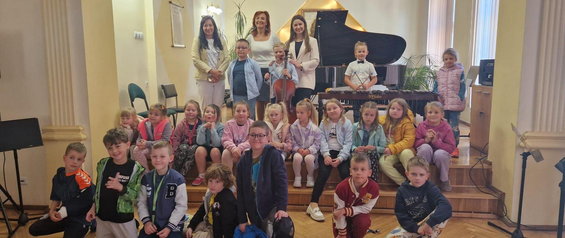 Galeria 20 zdjęć z audycji muzycznych, które odbyły się 09 maja w auli PSM w Kłodzku. Na zdjęciach uczniowie, którzy przyglądają się jak wygląda nauka w szkole muzycznej.