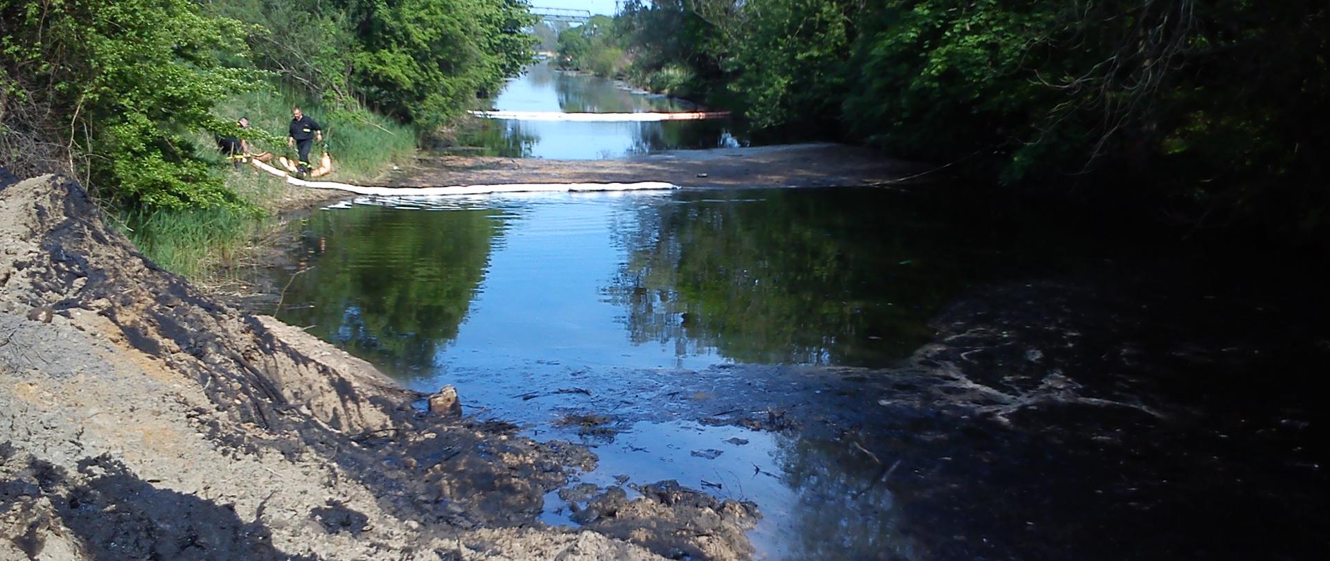 Zdjęcie przedstawia ciek wodny zabezpieczony zaporą przeciwolejową
