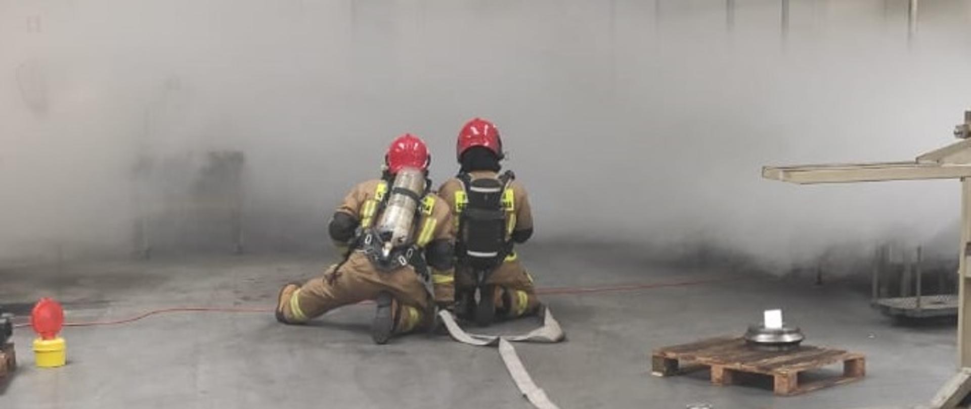 Strażacy podczas ćwiczeń w hali produkcyjnej