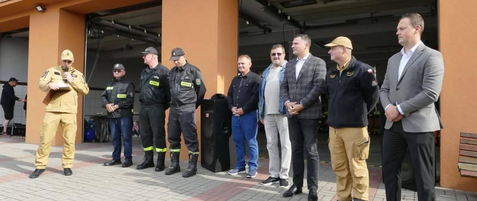 Zdjęcie przedstawia ludzi stojących prze budynkiem Włodarze Powiatu, Gminy, Komendant Powiatowy PSP