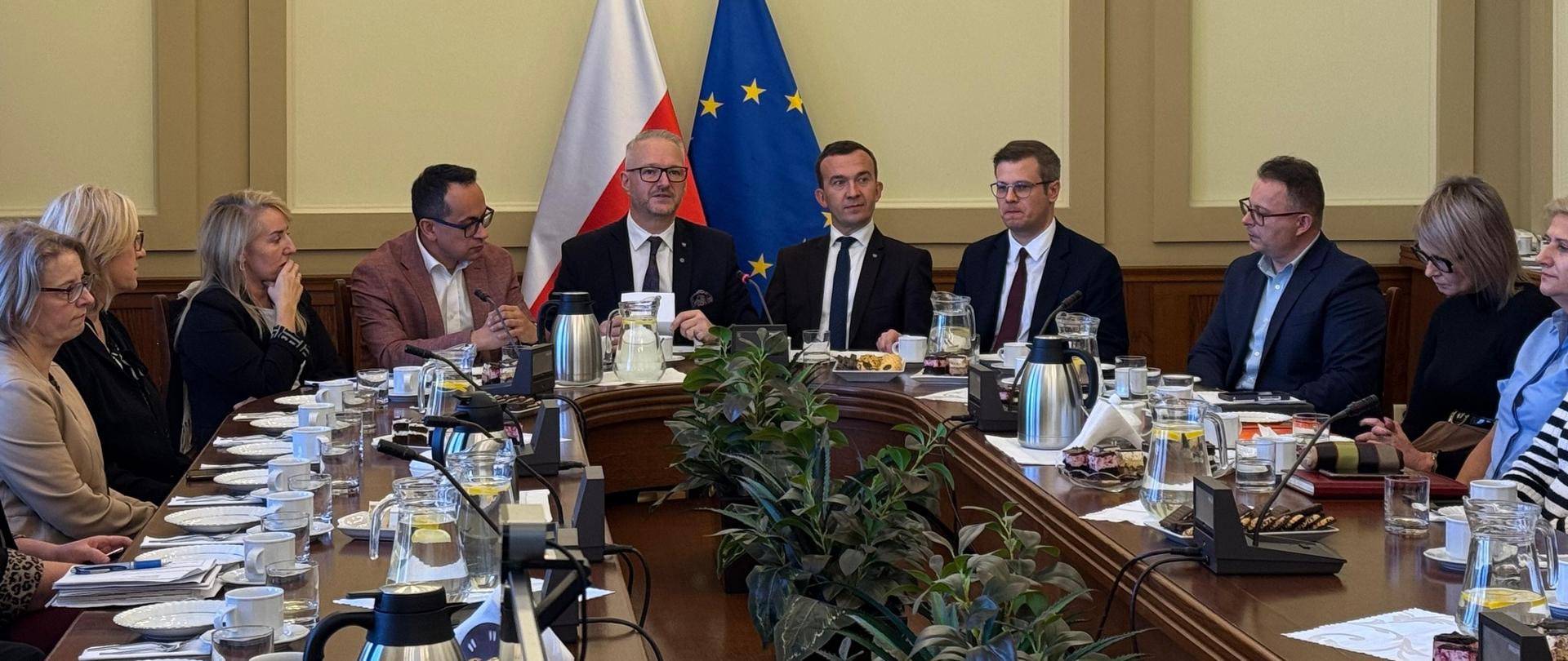 Kilkanaście osób siedzi przy stole