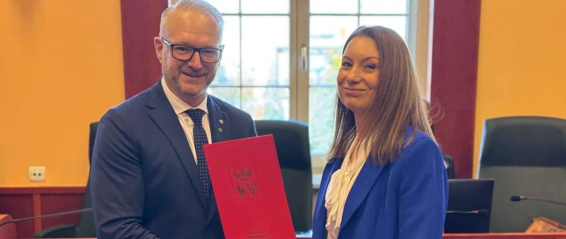 Posiedzenie Wojewódzkiej Rady Dialogu Społecznego: wojewoda Radosław Król wręcza powołanie na członka Rady Monice Choroszewskiej-Pleńkowskiej, Dyrektor Generalnej Warmińsko-Mazurskiego Urzędu Wojewódzkiego w Olsztynie.