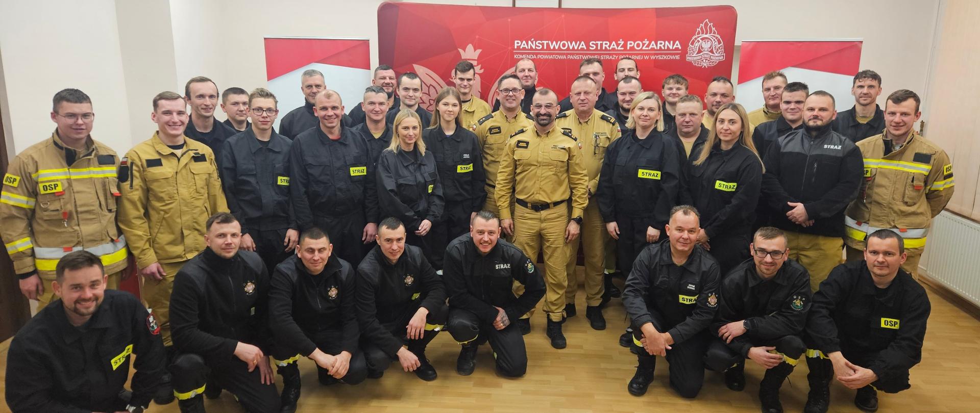 Zdjęcie grupowe strażaków ochotników po zdanym egzaminie z komisją egzaminacyjną.