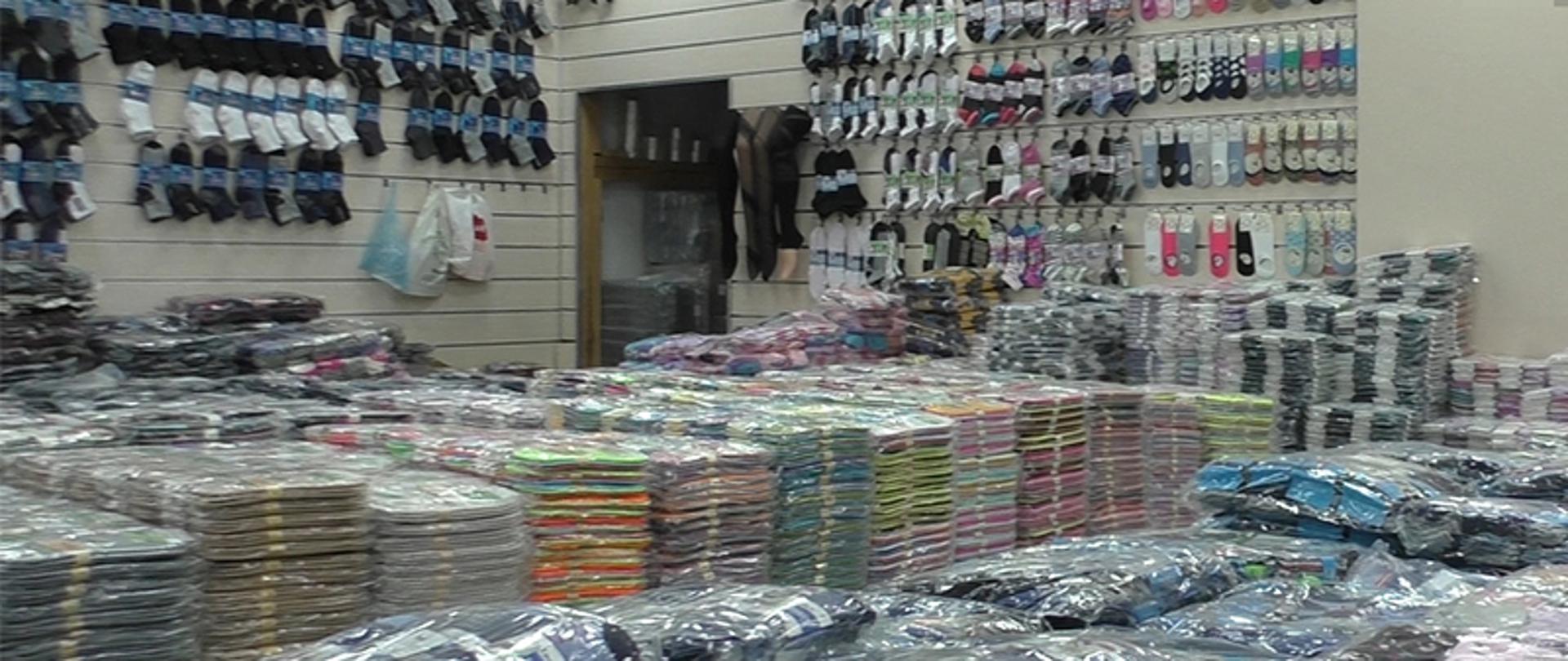 Pomieszczenie z podrobionymi towarami, m.in. koszulki, skarpety.