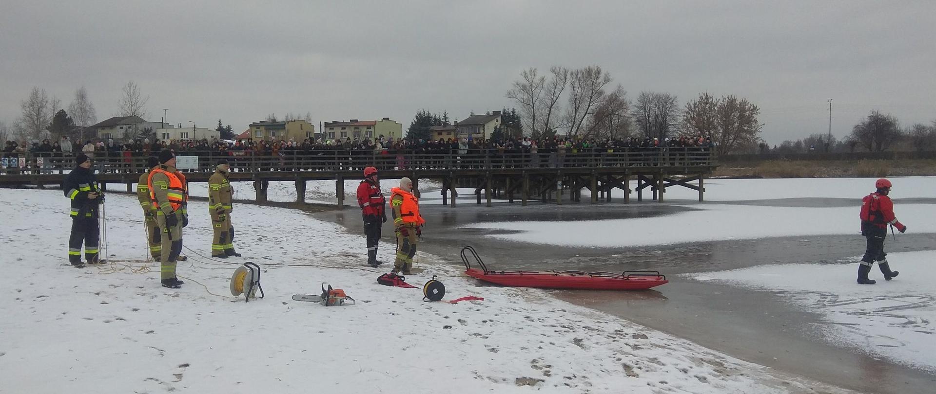 Zdjęcie przedstawia strażaków podczas pokazu z ratownictwa lodowego.
