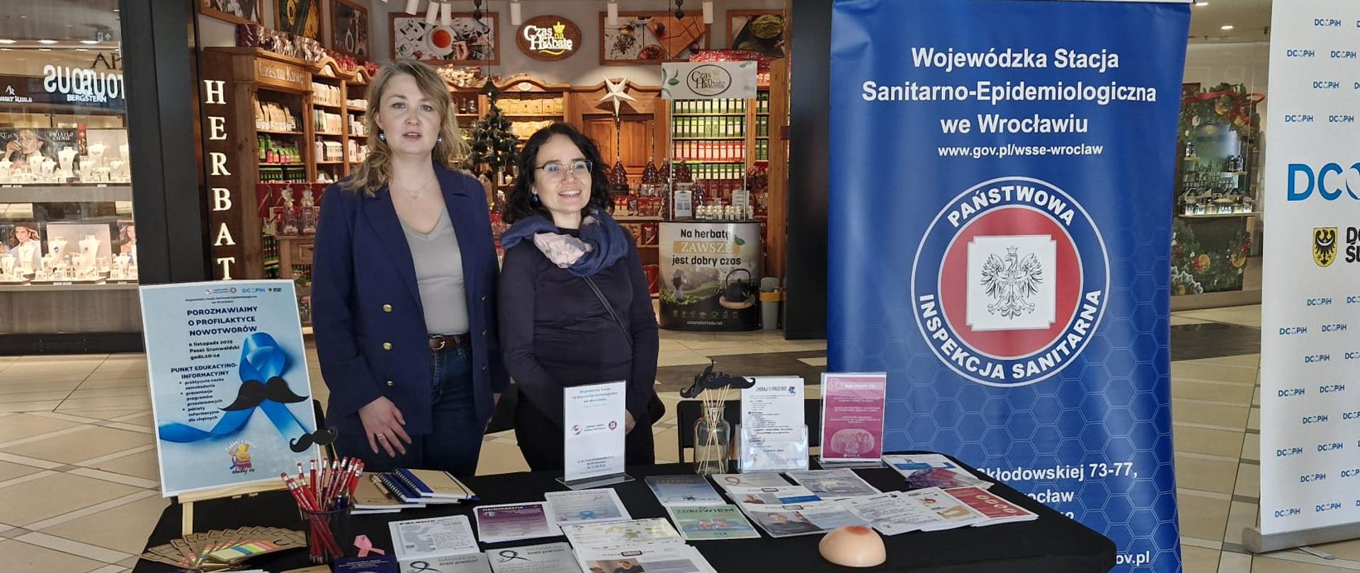 Osoby stojące przy punkcie edukacyjnym