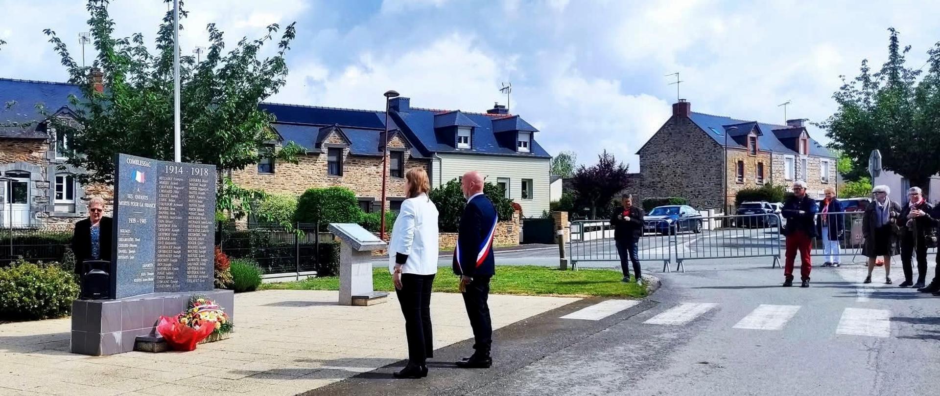Kobieta i mężczyzna stoją przed tablicą pamiątkową.