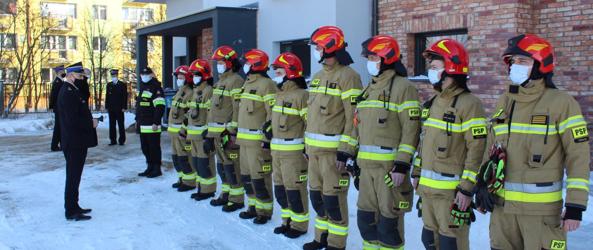 Uroczysta zbiórka przed budynkiem Komendy Powiatowej Państwowej Straży Pożarnej w Świeciu na powitanie Kujawsko-Pomorskiego Komendanta Wojewódzkiego starszego brygadiera Jacka Kaczmarka. Na pierwszym planie w szeregu stoi zmiana służbowa w ubraniach specjalnych. Na drugim planie na początku szeregu Dowódca Jednostki Ratowniczo-Gaśniczej młodszy brygadier Paweł Puchowski. W tle bokiem stoi Komendant Powiatowy starszy brygadier Piotr Tkaczyński wraz ze swoim Zastępcą starszym brygadierem Andrzejem Rafalskim. 