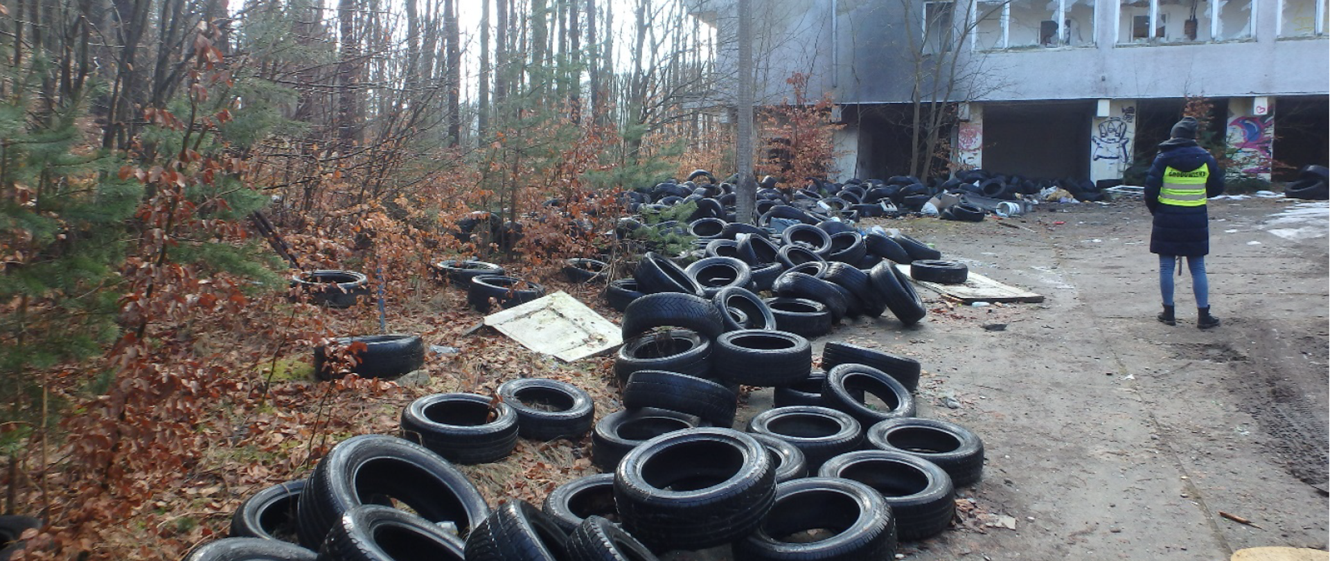 Odpady w postaci opon rozrzucone na ziemi wokół budynku