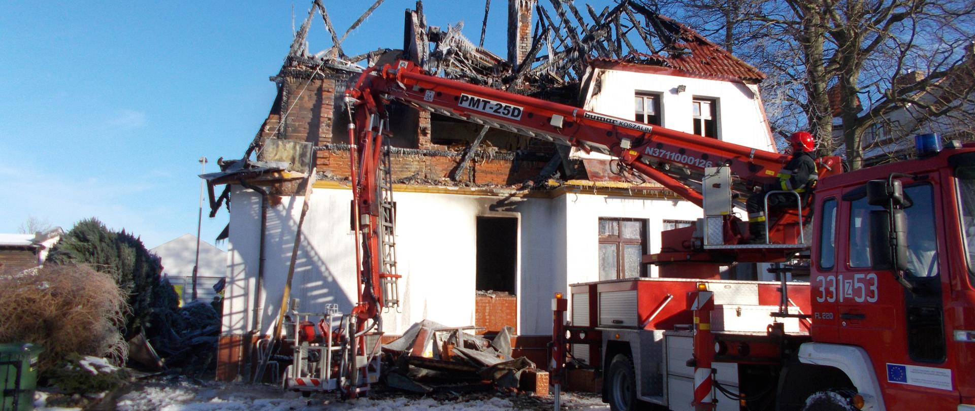 Pogorzelisko po pożarze budynku mieszkalnego w miejscowości Sarbinowo podczas prac rozbiórkowych z podnośnika SH-25