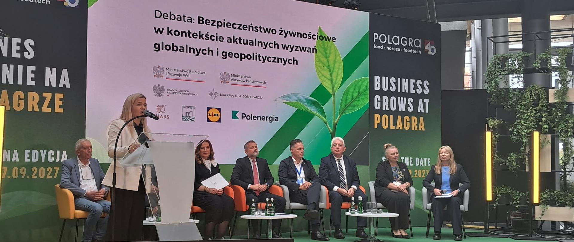 Debata o bezpieczeństwie żywności z udziałem ośmiu osób. Wśród uczestników Dorota Bocheńska, Główny Inspektor IJHARS. Na scenie przemawia Małgorzata Gromadzka, sekretarz stanu w Ministerstwie Rolnictwa i Rozwoju Wsi.