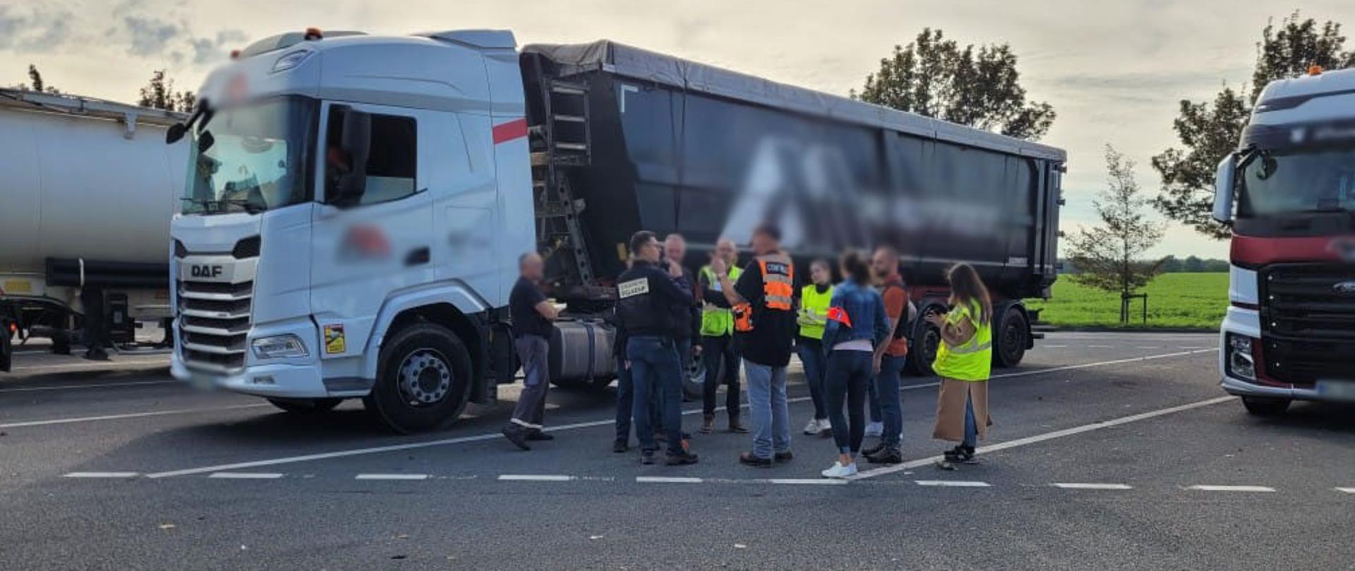 Parking, ciężarówki, ludzie