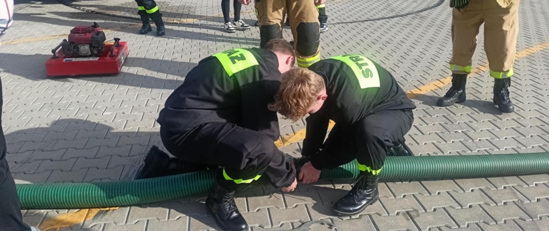 Łączenie węża strażackiego podczas ćwiczeń.