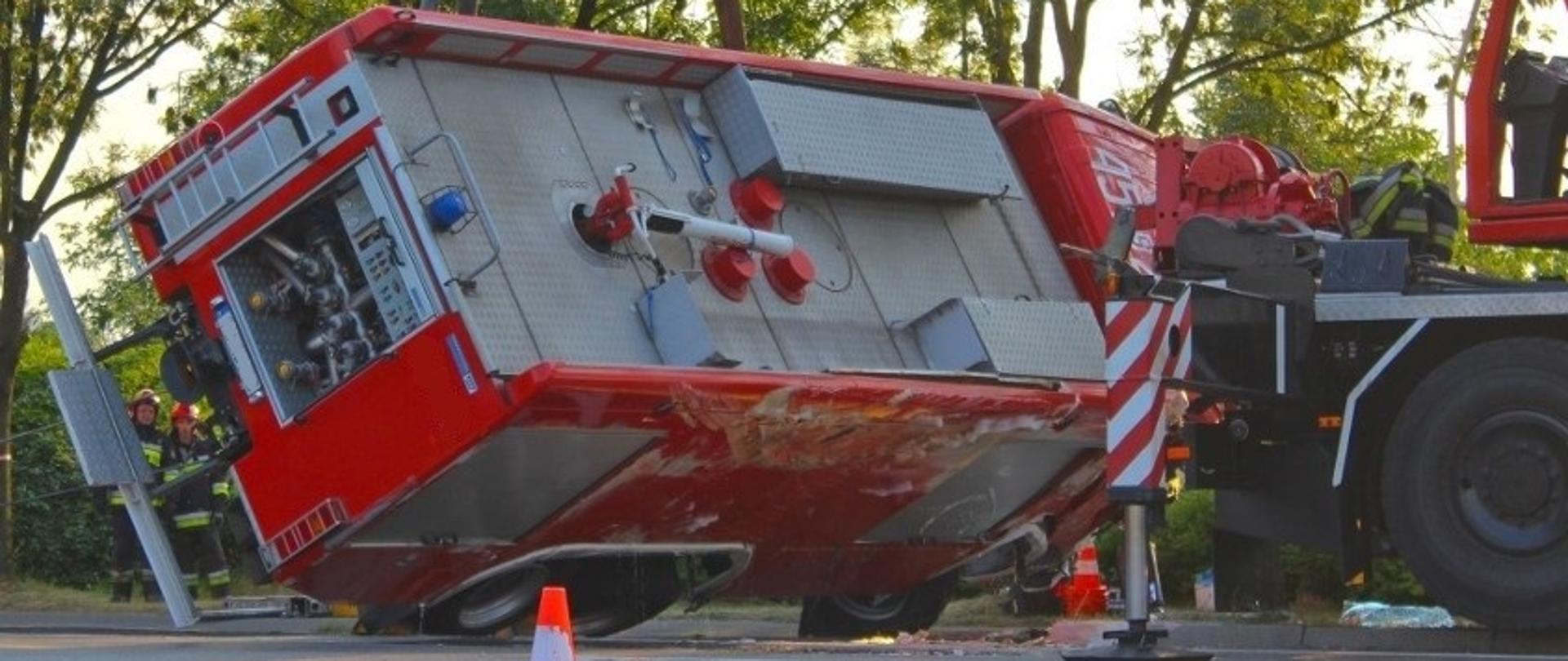 Przechylony pojazd pożarniczy po kolizji