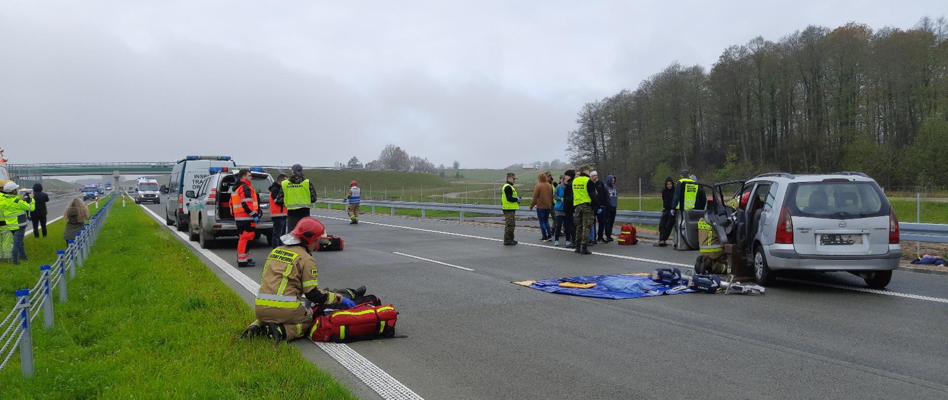 Zdjęcie obrazuje ćwiczenia strażaków i innych służb widać pojazdy i ludzi 