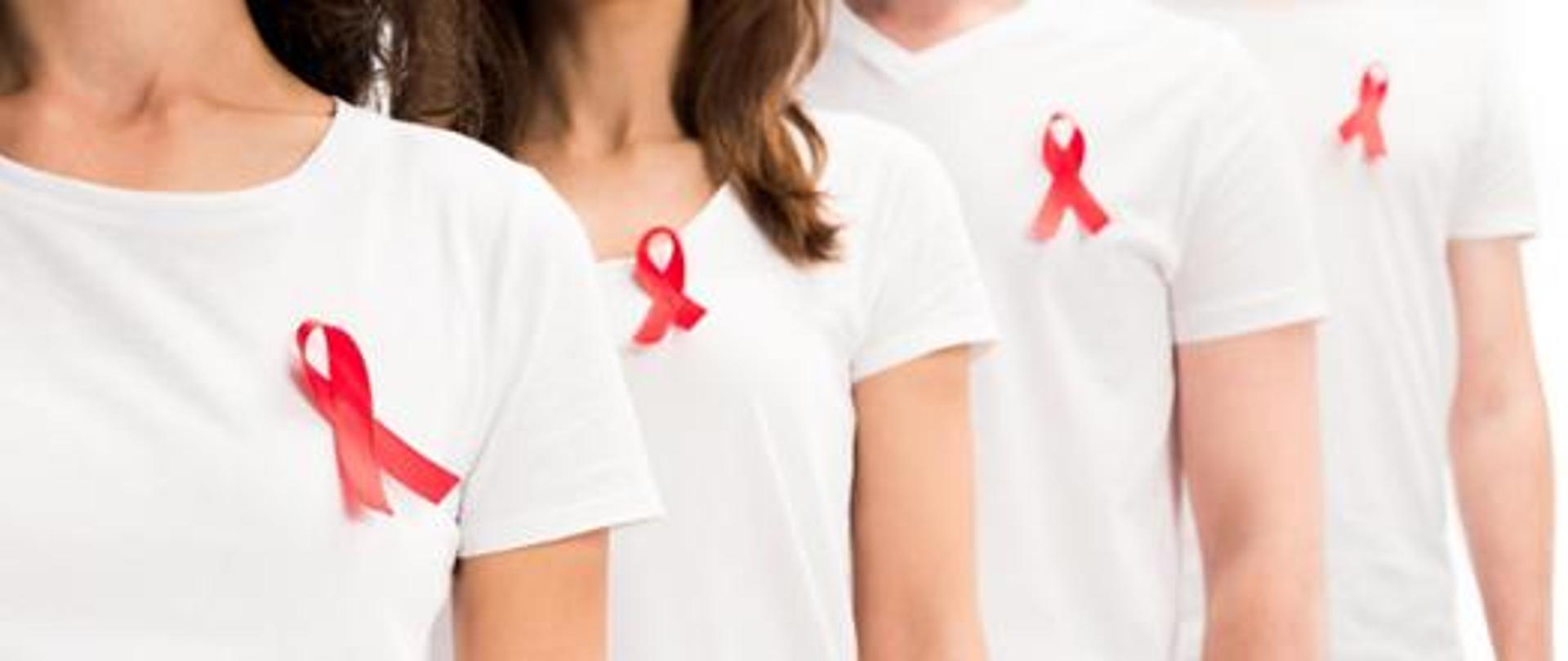 osoby w białych koszulkach z czerwoną wstążką, znakiem tolerancji osób z HIV i AIDS