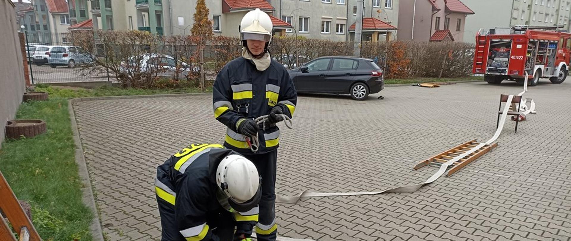strażacy przygotowujący linie gaśniczą