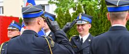 Strażacy oddają honor jedni stoją plecami drudzy przodem 