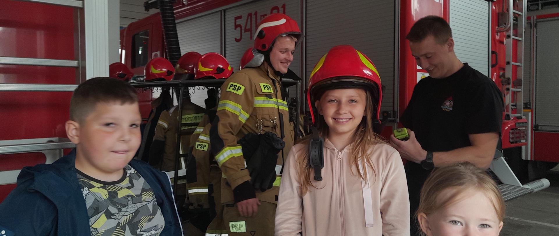 Dzieci w garażu straży pożarnej poznające sprzęt