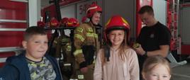 Dzieci w garażu straży pożarnej poznające sprzęt