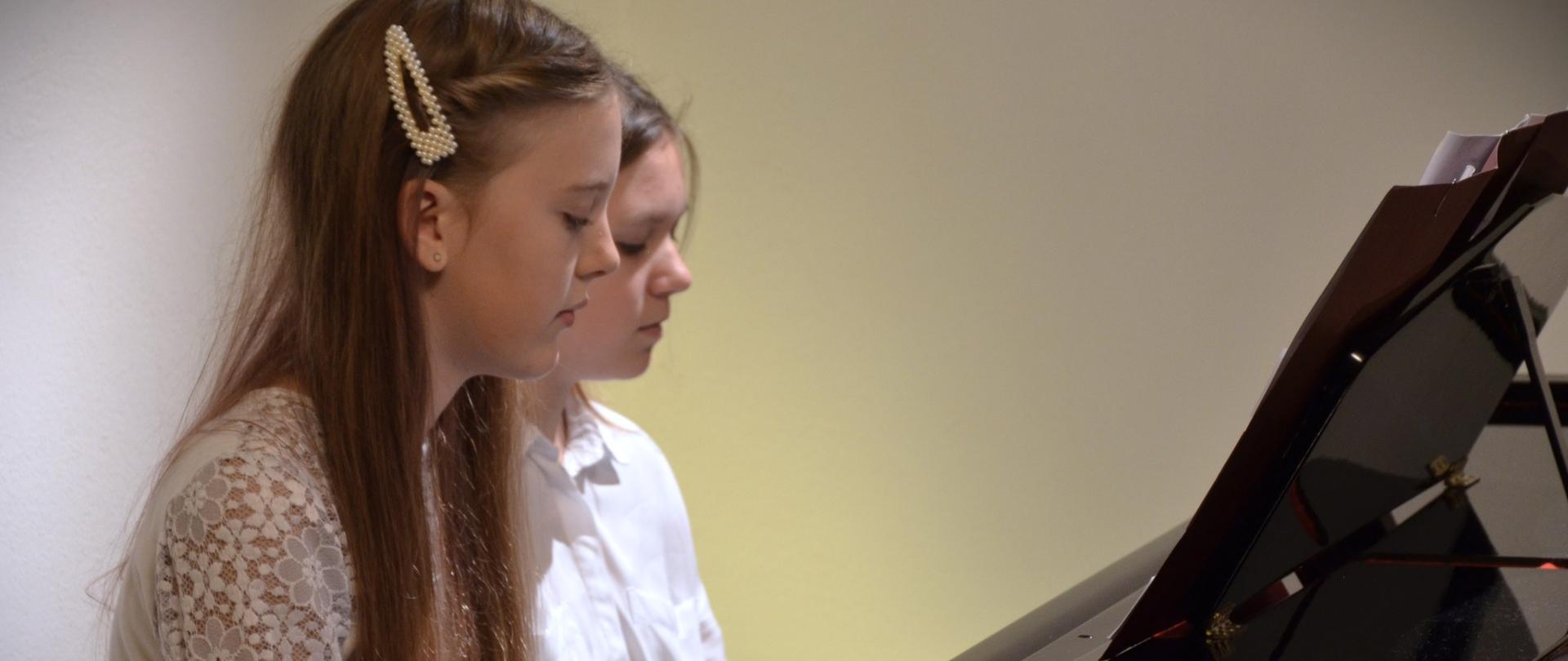 Dwie uczennice grają na fortepianie na 4 ręce