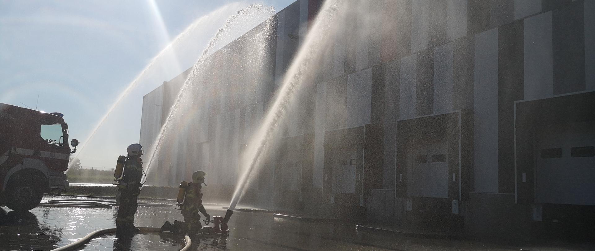 strażacy podają wodę z działek wodnych