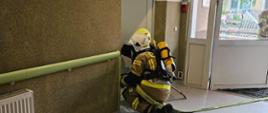 Pożar w budynku Ośrodka Opiekuńczo – Pielęgnacyjnego. Na pierwszym planie widać rotę z linią gaśniczą zabezpieczoną w aparaty ochrony układu oddechowego działającą wewnątrz budynku. 