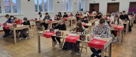 Ogólnopolski Turniej Wiedzy Pożarniczej 2025. Młodzież podczas pisania testów, siedzą w rzędach. 