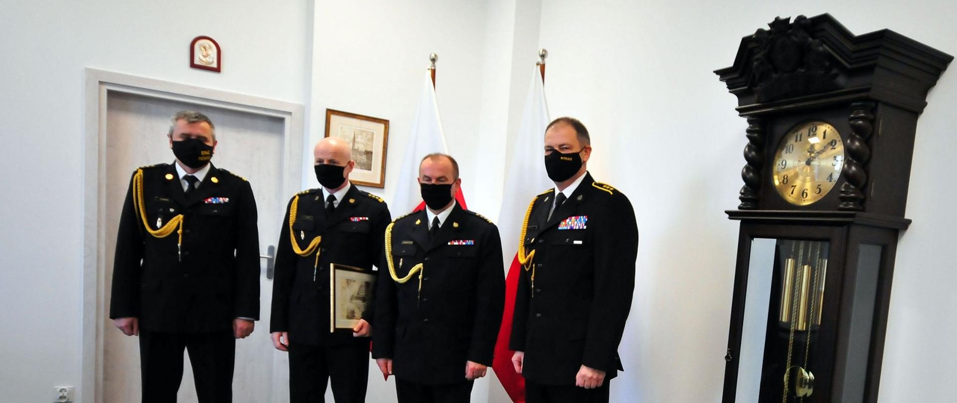 Zdjęcie pamiątkowe przedstawiające: pomorskiego komendanta wojewódzkiego PSP st. bryg. Piotra Sochę, st. bryg. Grzegorza Kmiecika, komendanta powiatowego PSP st. bryg. Jacka Niewęgłowskiego oraz zastępcę dowódcy JRG nr 3 w Gdyni asp. sztab. Tomasza Richerta. 