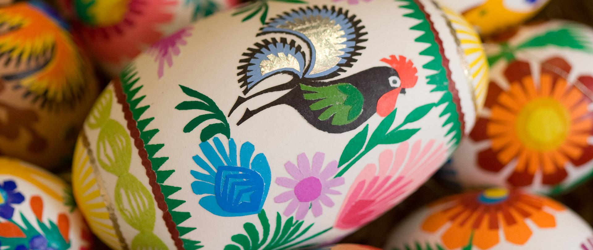 Pisanki wielkanocne ozdobione motywami inspirowanymi tradycyjnymi wycinankami łowickimi. Jajka mają intensywne, żywe kolory – dominują czerwienie, zielenie, żółcie i błękity.