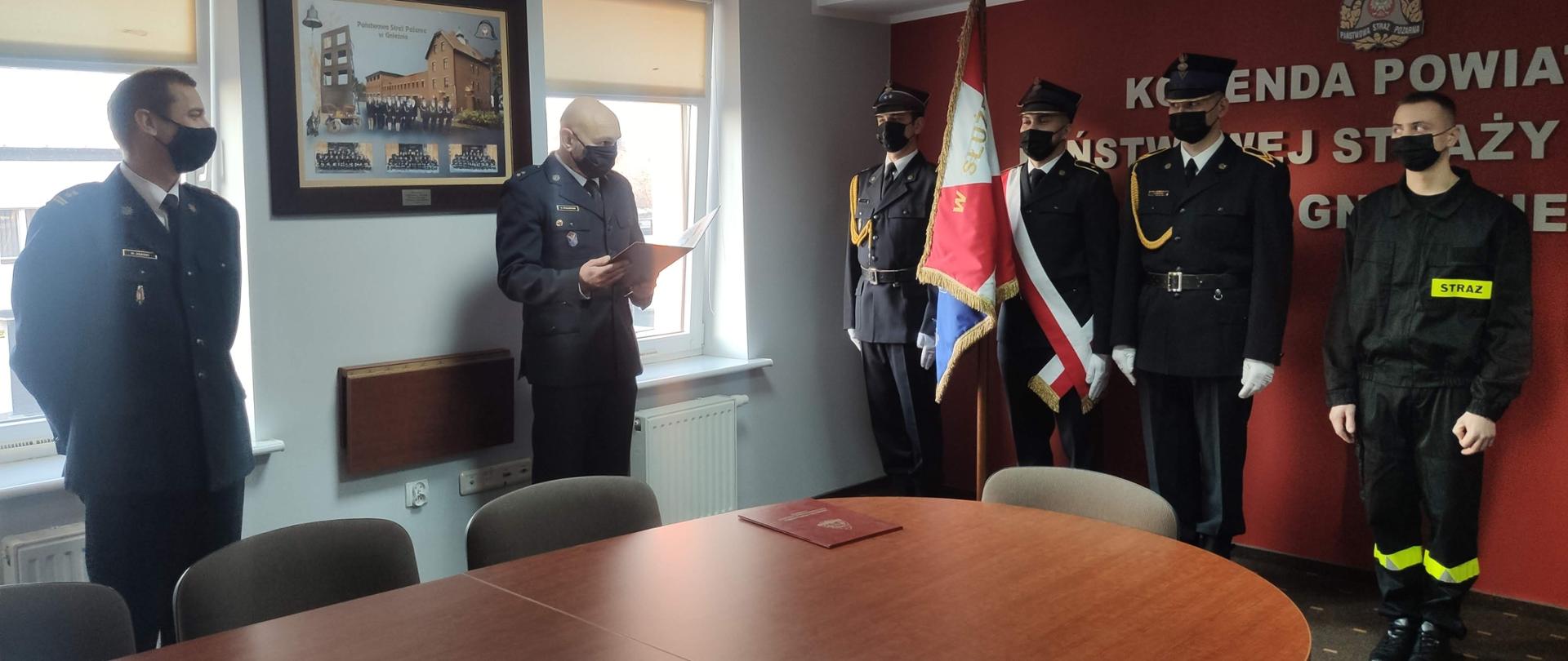 Strażacy w mundurach wyjściowych wraz z pocztem sztandarowym podczas ślubowania.