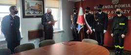 Strażacy w mundurach wyjściowych wraz z pocztem sztandarowym podczas ślubowania.
