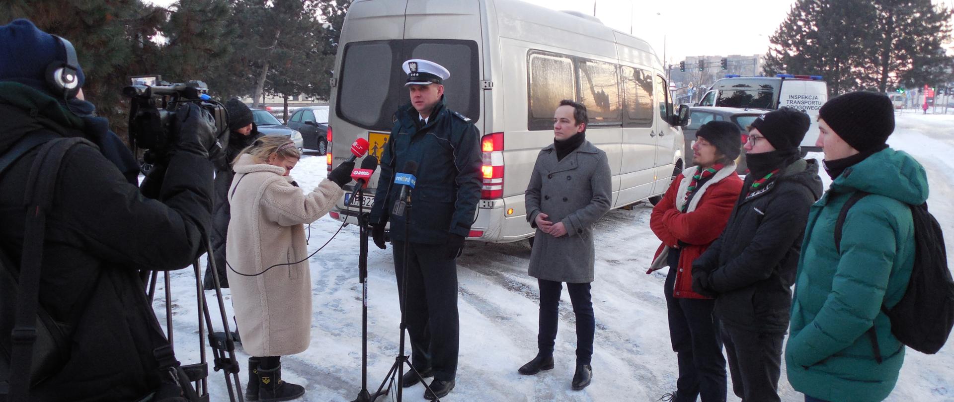Briefing w miejscu kontroli autokaru wyjeżdżającego na zorganizowany wypoczynek harcerzy z Radomia w okolice Częstochowy. O szczegółach akcji „Bezpieczny Autokar - ferie 2026” opowiedzieli Wicewojewoda Mazowiecki Patryk Fajdek, Mazowiecki Wojewódzki Inspektor Transportu Drogowego Zbigniew Kapciak oraz przedstawiciel Kuratorium Oświaty i organizator wyjazdu na zimowy wypoczynek.