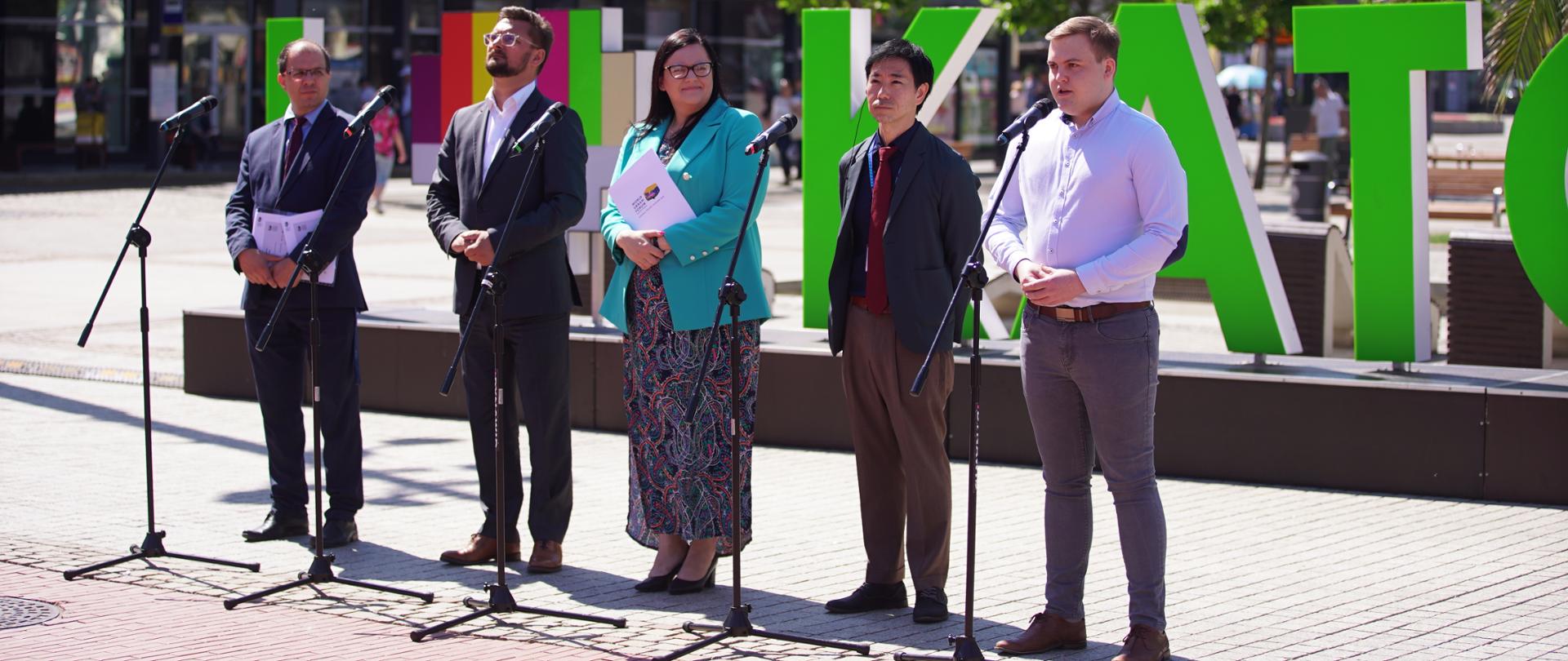 W mieście pięć osób stoi przed mikrofonami. W środku wiceminister Małgorzata Jarosińska-Jedynak.